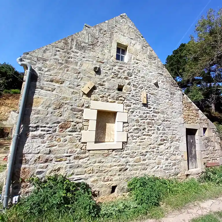 Une nouvelle ouverture a été créée dans le pignon, réalisée en pierre de taille, pour apporter lumière et caractère tout en s'intégrant harmonieusement à l'architecture existante.